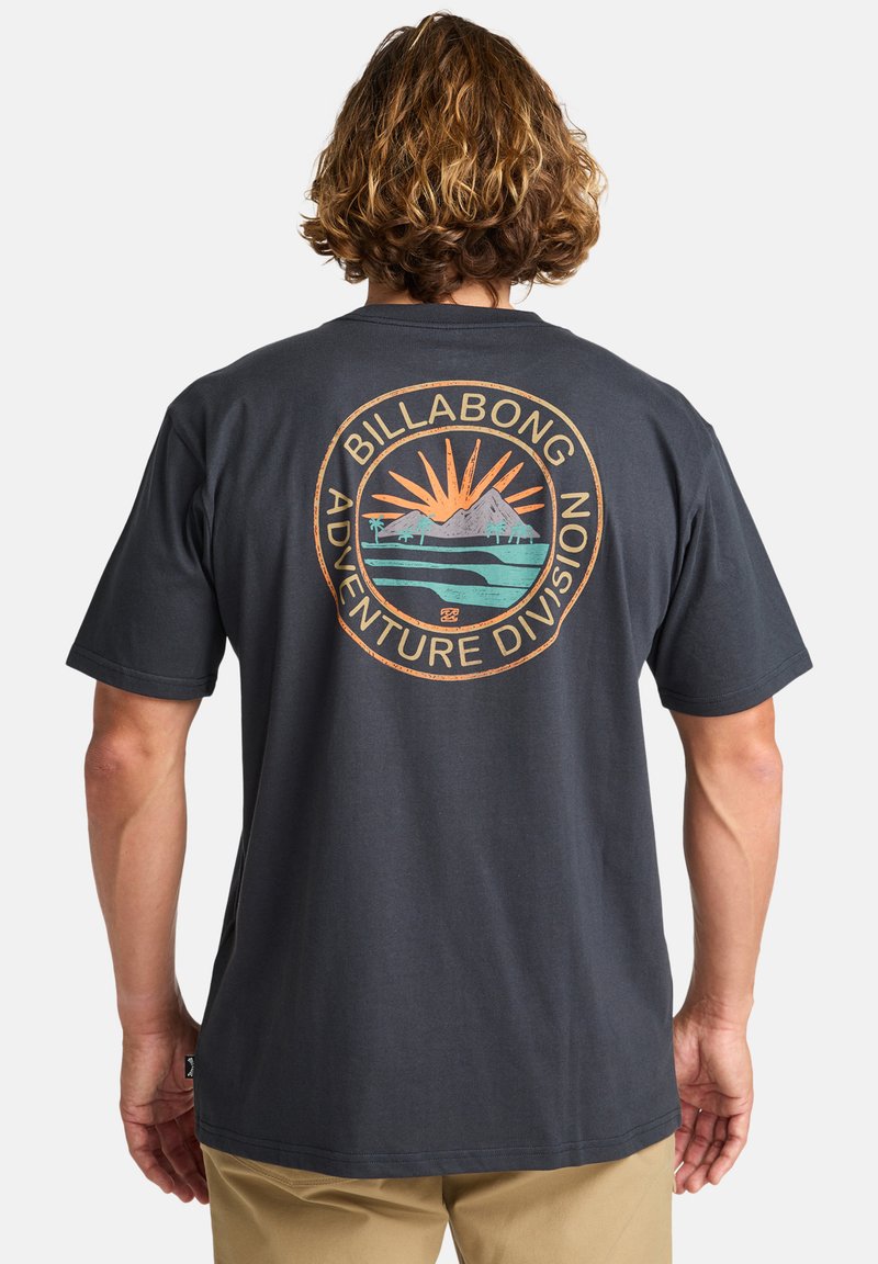 Svart t-skjorte med kort erme som har et sirkulært grafisk design i oransje, grønn og blå på baksiden med teksten "BILLABONG ADVENTURE DIVISION".