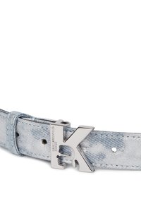 Světlý šedý denimový pásek s kovovou stříbrnou sponou ve tvaru písmene "K", na které je vyryto "Calvin Klein Jeans" na bílém pozadí.