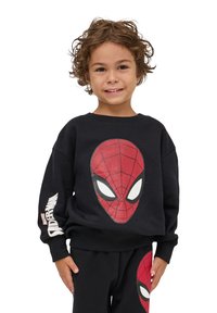 Felpa nera con una grande grafica del volto di Spider-Man in rosso e dettagli bianchi, abbinata a pantaloni coordinati con lo stesso design.