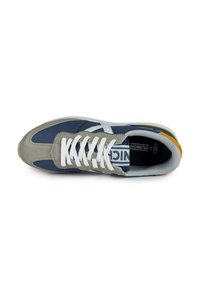 Zapatilla en navy y gris con material de ante y malla, cordones blancos y un acento amarillo en el talón. Presenta una suela de goma y detalles del logo.
