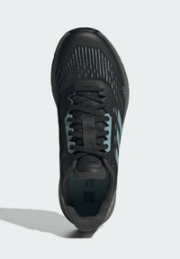 Scarpa da ginnastica nera con upper in maglia a motivo, dotata di dettagli blu chiaro e lacci neri. Punta arrotondata e design della suola texturizzata.