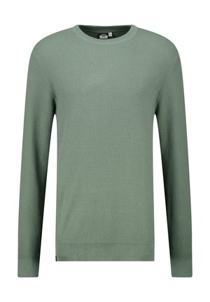 Vihreä tekstuuri neuletakki, jossa on pyöreä pääntie, pitkät hihat sekä ribbiret ja helma. Kankaan läpi kulkee vohvelineulekuvio.