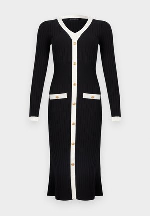Langes schwarzes, geripptes Strickkleid mit weißem Besatz, goldfarbenen Knöpfen vorne und zwei aufgesetzten Taschen, mit langen Ärmeln und V-Ausschnitt.