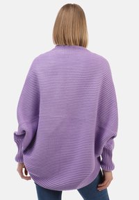 Lilla kootud sviiter laia lõikega, ribidega mansettide ja tekstuurse triibumustriga. Pehme kangas ja ümmargune hem detail.