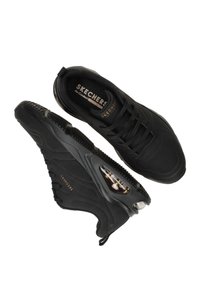 Sneakers neri con upper in tessuto testurizzato, punta arrotondata e chiusura con lacci. Presentano suola ammortizzata e il marchio Skechers sulla soletta.