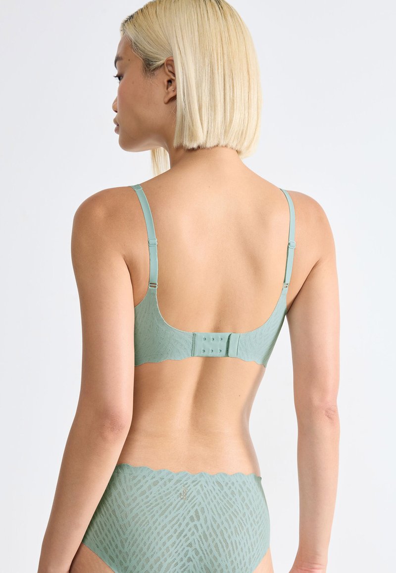Mint green lace bra featuring a scalloped edge, adjustable straps, and back closure with hook-and-eye detail. Smooth textured fabric.
