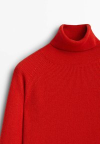 Rode turtleneck trui met een ribbelstructuur, voorzien van een hoge, nauwsluitende kraag en raglanmouwen. De stof lijkt zacht en knus.