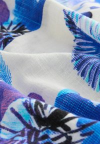 Lengvas audinys, su spalvingu palmų lapų raštu mėlynos ir violetinės spalvos ant balto fono. Lygus tekstūra su ryškiomis spalvomis.