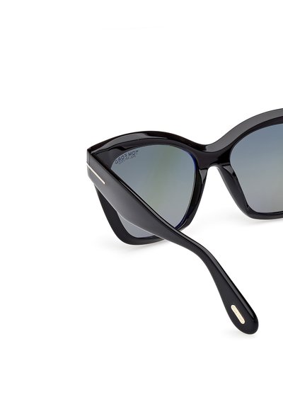 Musta kissalasisilmä aurinkolasit, joissa on gradienttiset linssit, kiiltävä pinta ja hillitty hopeinen metallivarustus kehystyksessä.