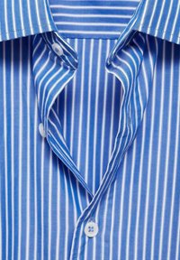 Camicia a strisce blu con strisce verticali bianche, dotata di colletto classico, patta con bottoni e texture in cotone morbido.