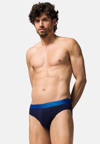 Granatowe slipki z fakturowanym pasem w niebieskim odcieniu. Model dopasowany, wykonany z gładkiego materiału.