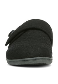 Black quilted slip-on slipper with a rounded toe, fabric upper, adjustable strap with a button detail, and grey textured sole.