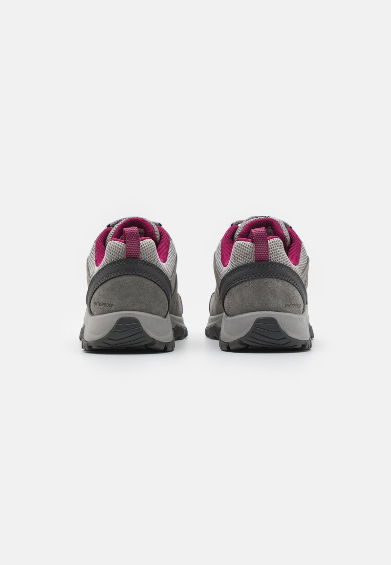 Une paire de chaussures de randonnée imperméables grises et roses vues de l'arrière sur un fond blanc.