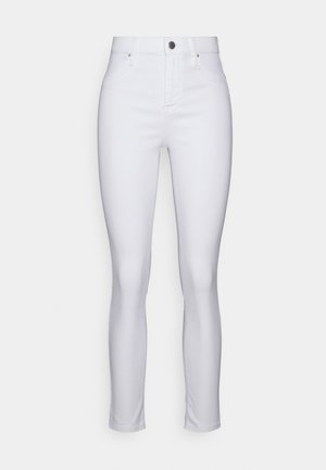 Jeans skinny brancos em denim com uma cintura alta, apresentando um design de bolso frontal, um botão metálico e uma textura suave.