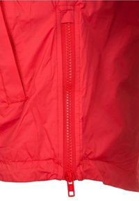 Red lightweight jacket featuring a central zipper, smooth texture, and side pocket. Zipper and accents are also in red.