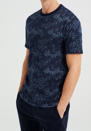 Marineblaues T-Shirt mit kurzen Ärmeln und einer strukturierten, blattförmigen Musterung. Rundhalsausschnitt, weicher Stoff, figurbetonter Schnitt und dezente Akzente im gesamten Design.