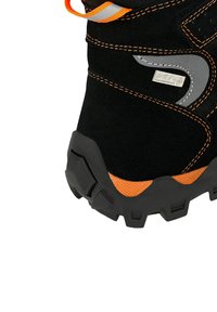 Zwarte wandelschoen met oranje accenten, waterdichte stof, robuuste zool met diep profiel en reflecterende details op de bovenkant voor zichtbaarheid.
