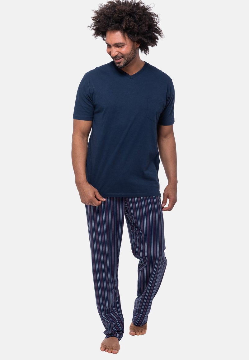 Navy sininen puuvillainen V-kaula-aukkoinen t-paita, jossa on lyhyet hihat ja rintatasku, yhdistettynä raidallisiin yöpukuhousuihin, joissa on sinistä, punaista ja valkoista.