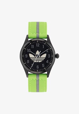 Montre noire avec un boîtier rond, bracelet en tissu vert avec des rayures grises, et un cadran noir avec des chiffres et un logo blancs.
