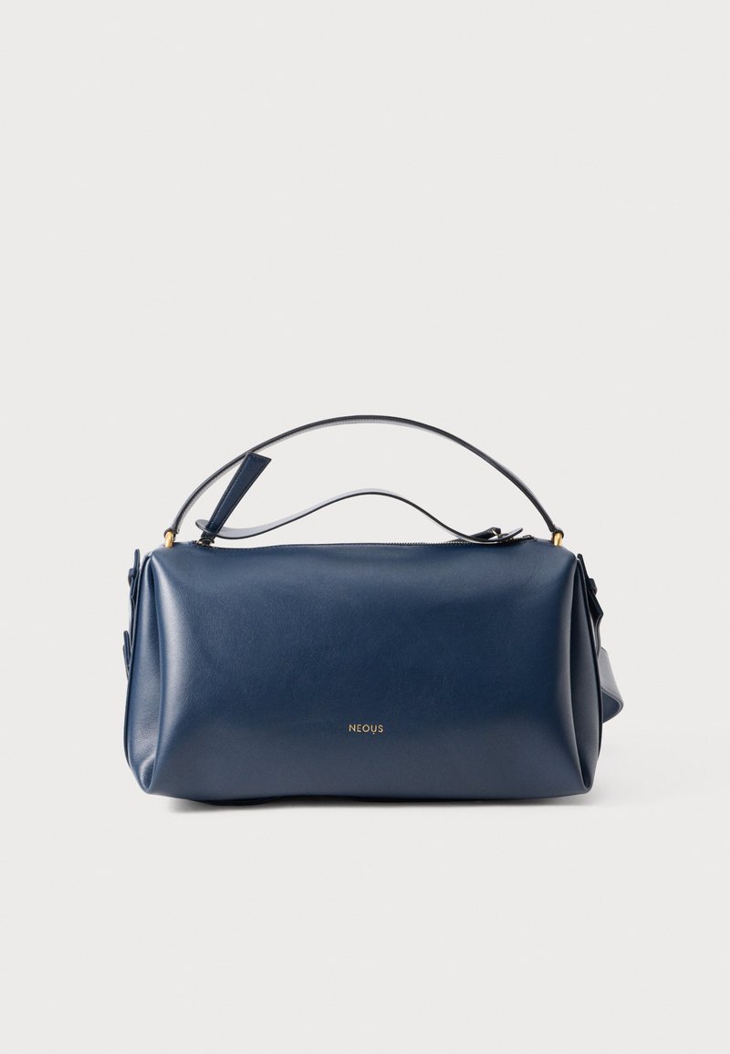 Borsa da viaggio in pelle blu navy con forma rettangolare, manico superiore, logo dorato e texture liscia. Chiusura con zip e dettagli laterali.