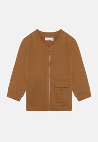 Chaqueta marrón con cremallera, hecha de un tejido suave, que presenta mangas largas, un cuello redondo, un bolsillo frontal y puños acanalados.