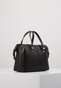 Bolso de mano de cuero negro con una textura de piel de melocotón, forma redondeada, asas dobles y detalles en metal plateado; cuenta con un cierre de cremallera en un lado.