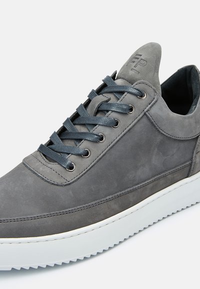 Grå lærersneaker med lavt design, rund tå, tonede snørebånd, metallegnagler og en polstret hvit såle.
