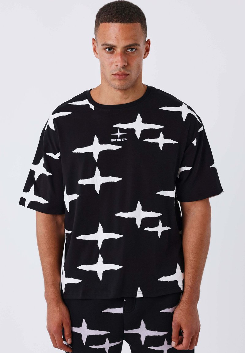 T-shirt noir avec un motif d'étoiles blanches audacieux, manches courtes, encolure ronde et un petit logo sur la poitrine. Fabriqué en tissu doux.