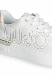 Weißer Sneaker mit Obermaterial aus Stoff und goldenen Akzenten. Verfügt über das Logo "LIU:JO" in erhabener Schrift und eine weiße Gummisohle mit metallischen Details.