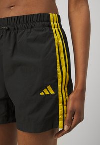 adidas Sportswear ESSENTIALS 3 STRIPES LIFESTYLE - Sporta šorti - black/hazy yellow