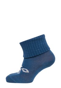 Blå ankelstrumpa med ribbad mudd, med en slät textur och ett vitt logomönster nära tån.