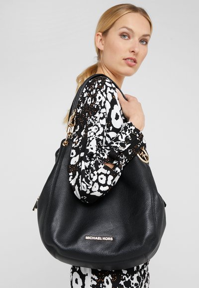 Sac hobo en cuir noir avec surface texturée, quincaillerie dorée et nom de marque en relief. Anse attachée et design ample.