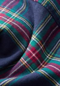 Gewebter Karo-Stoff mit dunkelblauem Grund und grünen, roten, gelben sowie weißen Karomustern, weiche Textur mit sichtbarem Gewebe.
