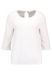 Vit blus med 3/4-lång ärm, rund halsringning och nyckelhålsstängning i ryggen med knapppdetalj.