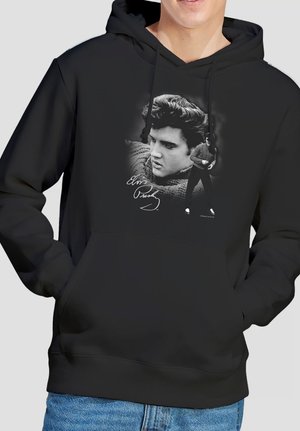 Black hoodie with black-and-white graphic of a young man in a sweater next to his signature on the chest area.