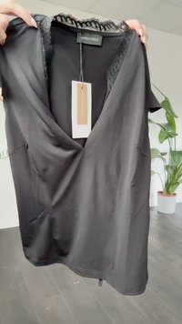 Black silk blouse with lace trim around the neckline, short sleeves, and side pockets. Tag attached, smooth texture.