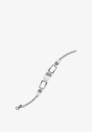 Bracelet en argent avec des maillons rectangulaires alternant entre pleins et ouverts, et un fermoir chaîne sur fond blanc.