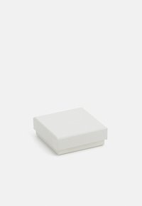 Valge ruudu kujuline kingituste kast, mis on valmistatud tekstureeritud paberist, millel on lame kaas ja servad. Mõõtmed on ligikaudu 5x5 tolli. Pole nähtavat brändingut.