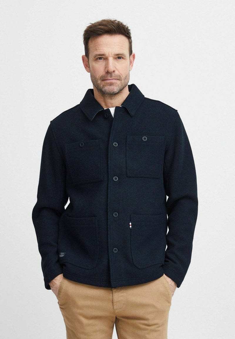 Navy wool blend jacket with a collar, button closure, and four pockets. Textured fabric, straight fit, and contrasting accents at the hem.