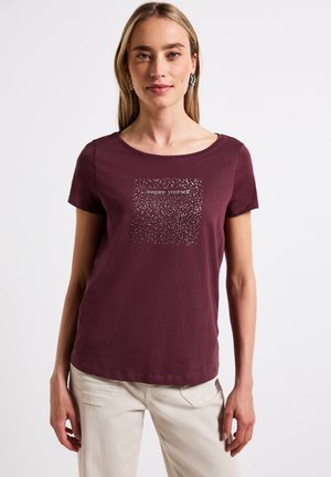 T-shirt à manches courtes bordeaux en tissu doux, avec un design graphique au centre portant le texte « inspire-toi ».