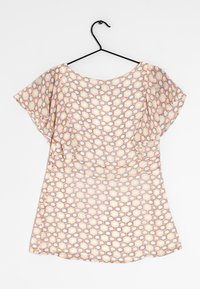 T-shirt à manches courtes en tissu léger, avec un motif en nid d'abeille dans des teintes pastel d'orange, de jaune et de gris sur fond crème.