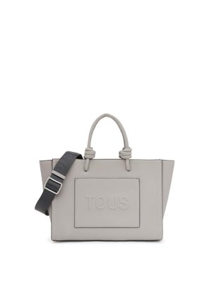 Sac à main en cuir gris avec deux poignées supérieures, une bandoulière amovible, un logo "TOUS" embossé sur le devant et une forme rectangulaire structurée.