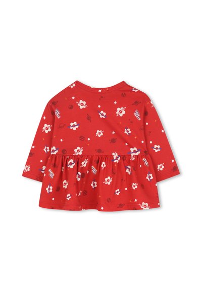 Chemise rouge à manches longues avec un ourlet évasé, des motifs floraux multicolores et des planètes, ainsi qu'un col rond. Tissu en coton doux.