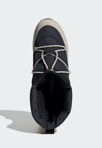 Černá zateplená bota s flexibilním designem, zdobená béžovou špičkou a šedými tkaničkami. Interiér má jemnou texturu a vzadu je poutko pro snadné obouvání.