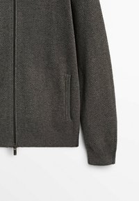 Dunkelgrauer Cardigan mit durchgehendem Reißverschluss und strukturiertem Waffelmuster. Verfügt über gerippte Bündchen, Saum und seitliche Taschen für Funktionalität.