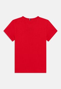 Κόκκινο βαμβακερό μπλουζάκι με κοντά μανίκια. Διαθέτει κλασική στρογγυλή λαιμόκοψη και καθαρή, λεία υφή. Χωρίς ορατά σχέδια ή διακοσμήσεις.