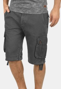 Men's dark gray cargo shorts made of cotton, featuring multiple pockets, button closures, and adjustable drawstrings at the hem.