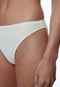 Weißer Bikiniunterteil aus strukturiertem Stoff mit einem karierten Muster; hat einen niedrigen Schnitt und einen weichen, elastischen Bund für maximalen Komfort.