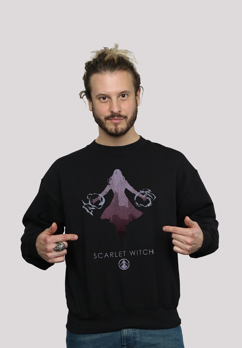 Svart genser med et grafisk motiv av en figur med en gradientdesign i rosa og lilla. Teksten "SCARLET WITCH" står under bildet.