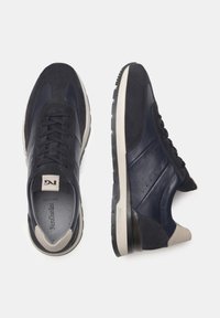 Sneaker blu realizzati in pelle e suede, con un design a punta arrotondata, accenti testurizzati e un inserto sul tallone in beige a contrasto.